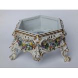A 19thC Meissen style porcelain hexagonal stand, the frieze applied with floral festoons, on three
