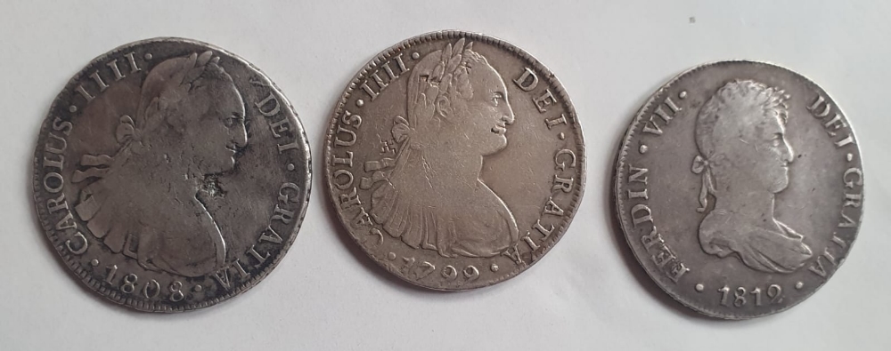 Three Spanish Colonial silver 8 Reales coins.
