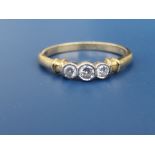 A modern collet set three stone diamond 18ct gold ring. Finger size Q.