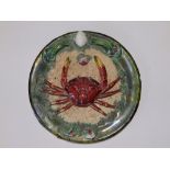 A Palissy ware style plate applied with a crab, 8.5" diameter.
