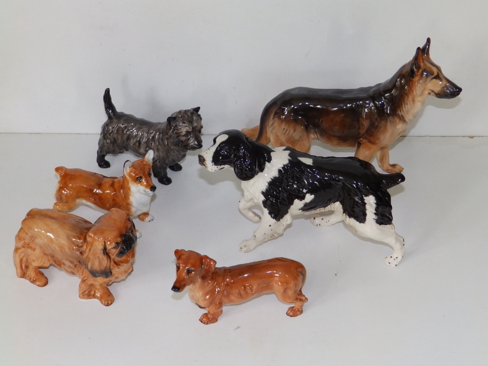 A Royal Doulton alsatian, 6" high, a black & white spaniel and four smaller Royal Doulton dogs. (6)