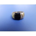 A diamond & black onyx set yellow metal ring of asymmetrical design. Finger size R.
