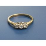 A small three stone diamond ring, claw set stones of total weight 0.25 carat, on 18ct gold shank.