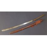 A 19thC Indonesian sword in wooden scabbard, having slightly curved 22.5" blade, the brass mounted