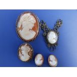 A modern 9ct gold oval cameo brooch, 1.75" and four smaller metal framed cameos. (5)