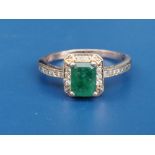 A natural untreated 1.2 carat emerald & diamond cluster ring, the four-claw set rectangular cut