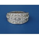 A diamond set white metal eternity ring, fashioned as a triple band to the front half. Finger size