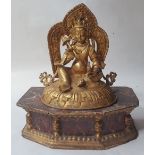 A gilt metal Tibetan figure, 7.1" high, on painted wood stand.