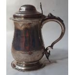 A large George III silver lidded tankard, the domed cover with scroll pierced thumbpiece, double-