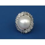 A large pearl & diamond cluster ring, the pearl of approximately 14.7mm diameter above two collars