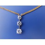 A three stone cubic zirconia drop pendant on 9ct necklace chain.