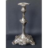 A George III rococo crested silver candlestick, having a leaf-cast sconce, the scroll-moulded stem
