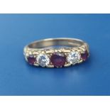 A graduated five stone ruby & diamond set 18ct gold ring. Finger size N.