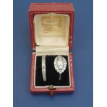 A Cartier ring box containing an Edwardian diamond set platinum cluster style ring, the shank