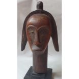 A carved African wood head on stand, the head 13" high.