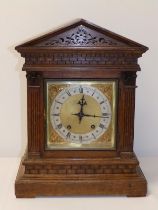 A 19thC German oak striking mantel clock with brass dial & triangular pediment, retailed by Reid &