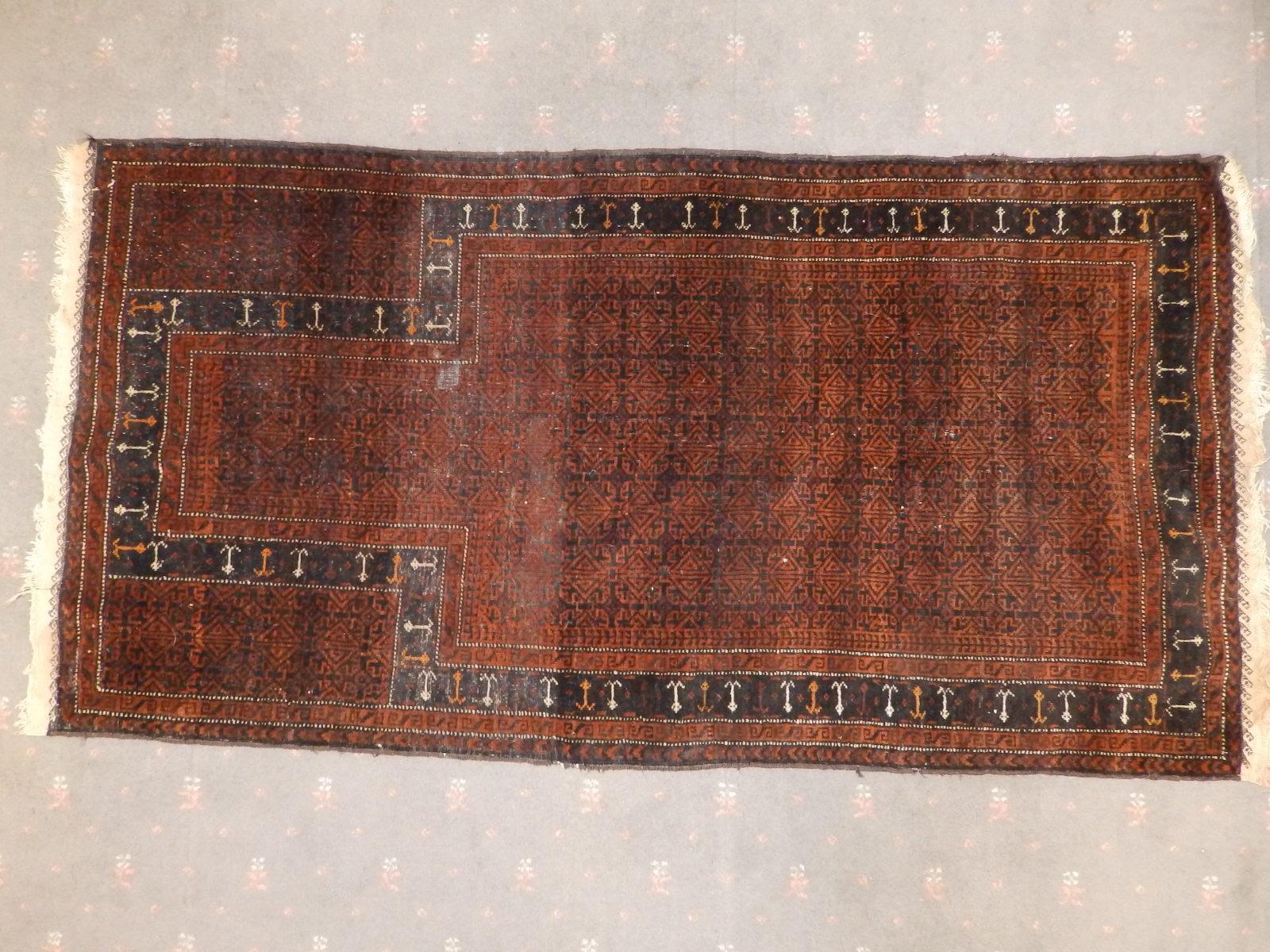 An old prayer rug, the field decorated with detailed geometric pattern in black & brown, cream