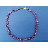 A Malcolm Betts graduated ruby bead necklace, on yellow metal clasp (tests as gold) with diamond