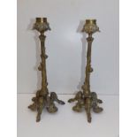 A pair of French art nouveau brass candlesticks, each cast with three snails ascending the leafy