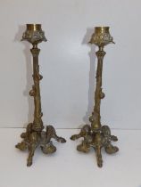 A pair of French art nouveau brass candlesticks, each cast with three snails ascending the leafy