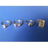 A rectangular cut citrine set 9ct ring and three other gem set 9ct rings. (4)