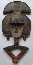 An African carved wood figural panel with sheet metal decoration - from the studio of Robert