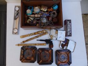 A wooden box containing an Eiffel Tower souvenir pipe in the form of a revolver and other