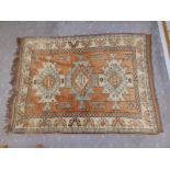 An Afghan rug woven in brown, cream & pale blue, the three geometrical medallions on a brown