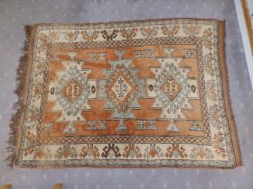 An Afghan rug woven in brown, cream & pale blue, the three geometrical medallions on a brown