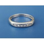 A seven stone diamond set platinum band ring. Finger size N.