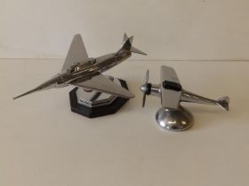 An art deco chrome plated jet fighter lighter, 9" across and a monoplane lighter. (2)