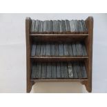 A set of 38 miniature Shakespeare volumes in three tier plywood rack, each book 2" high.