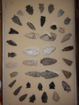 A collection of North American Indian stone arrowheads in glazed case.