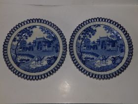 A pair of blue & white plates with ozier pierced borders, each depicting a camel with rider in the