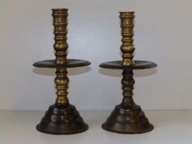 A near pair of late 17thC turned brass candlesticks in Heemskirk style, the stems of ring turned