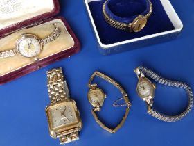 A boxed lady's Garrard gold presentation wrist watch on plated strap, two other ladies' gold watches