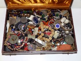 A jewellery box containing costume jewellery, beads and collectors' items.