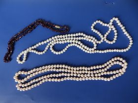 Two 50" feshwater pearl necklaces and a garnet necklace. (3)