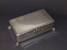 A silver cigarette box, on cast recumbent lion feet, Birmingham 1936, 6.5" across - some small areas