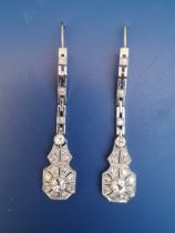 A boxed pair of art deco diamond millegrain set drop earrings, the two principal stones in each