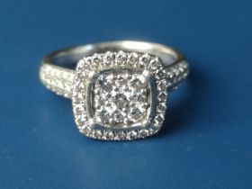A diamond set platinum cluster ring of square cushion form, pave set with numerous small diamonds,