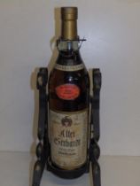 A jeroboam of Alter Berhardt brandy in wrought iron stand.