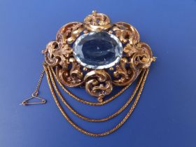 A large Victorian aquamarine set brooch, of oval open scroll form, set with a large faceted oval