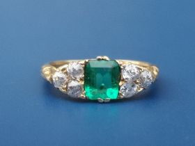 An emerald & diamond ring, the rectangular cut emerald flanked by six small old cut diamonds on