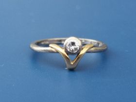 A small diamond collet set 18ct gold solitaire ring in wishbone setting. Finger size K.