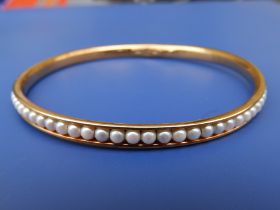 A pearl set 750 metal bangle, diameter 3".