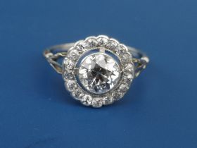 An Edwardian diamond set cluster ring, the central old cut stone weighing in excess of one carat, on