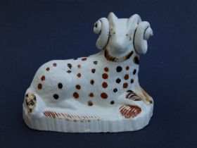 A George III creamware study of a recumbent ram, decorated with brown spots, of hollow form, reeding