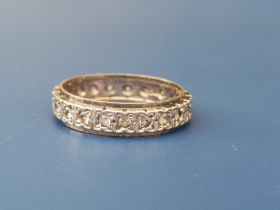 A diamond set yellow & white metal '18' eternity ring. Finger size N/O.