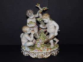 A continental porcelain group depicting three putti gathering fruit & flowers, 7" high.